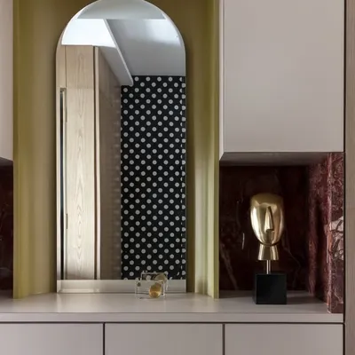 Golden hour, golden accents. This bar unit mixes luxe marble cladding and subtle glam. The cheeky polka dot wallpaper reflected in the mirror is one of those small details that brings joy to a space.
