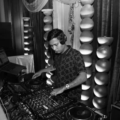 A black and white shot from a pre-wedding Sangeet event. I'm in the zone, focused on crafting the perfect mix for the night.