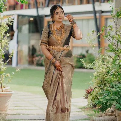 A full-length portrait of a South Indian bride in a stunning silk saree. We captured her in a beautiful garden setting, highlighting the elegance of her traditional attire and gold jewelry.