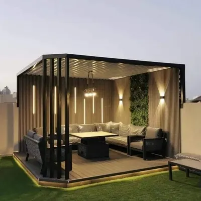 A modern pergola defines this rooftop seating area, featuring integrated vertical lights and a living green wall. This setup is ideal for evening gatherings, providing both style and comfortable seating for guests.