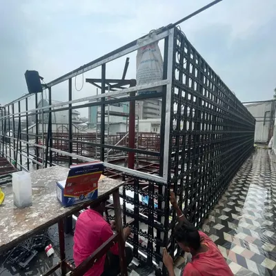 Our team at work on a large-scale rooftop installation. This image shows the metal framework and modular panels being assembled, which form the base of our vertical gardens.
