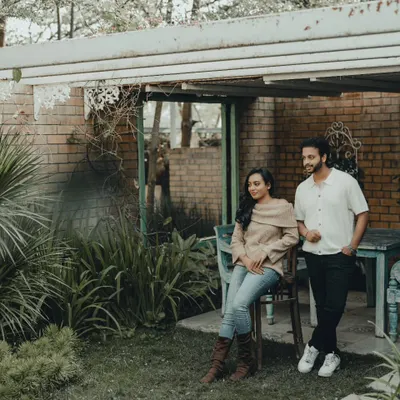 A quiet, candid moment during a pre-wedding shoot in a rustic garden setting. I focus on finding beautiful light and natural interactions between the couple.