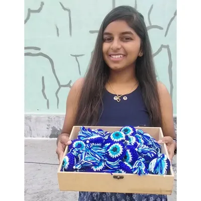 The artist with her proud art. This was my first ever bulk order of 40 evil eye keychains, a huge milestone for my small business that I'll never forget.