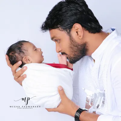 A father's gentle gaze says it all. We love creating these heartfelt portraits that capture the powerful connection between a parent and their newborn child.