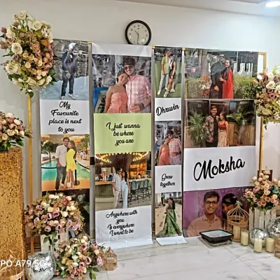 A personalized backdrop that tells the couple's story. I created custom banners with photos and quotes for Dhruvin and Moksha, framed with floral arrangements on sequin stands.