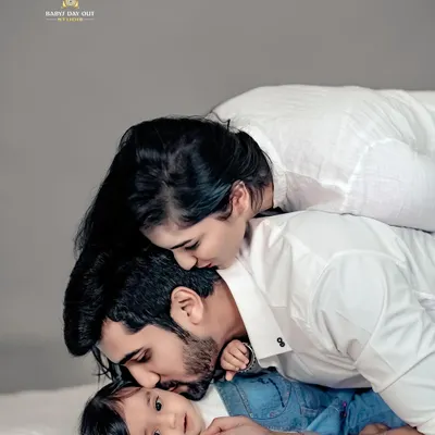 We believe the purest love is found in these quiet moments. This beautiful family portrait, with everyone in classic white, lets their deep connection be the absolute focus.