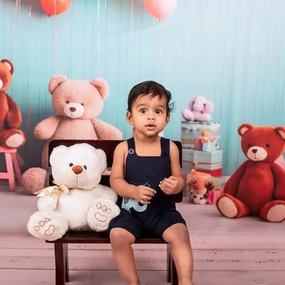 Before the smash. This little one is looking sharp in his overalls, posing in our teddy bear-themed first birthday setup before the cake comes out.