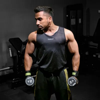 Focused and ready for a dumbbell workout. Maintaining a lean, muscular physique requires year-round dedication, even when not in active contest prep.