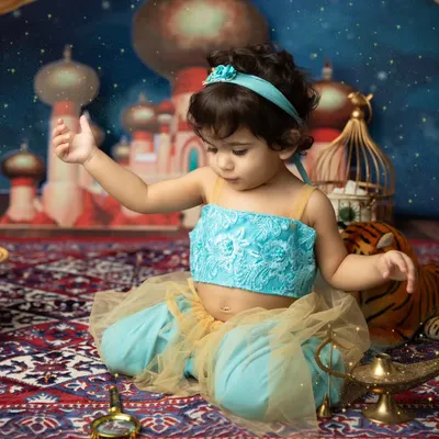 A whole new world. This little princess is dressed as Jasmine, exploring a magical Agrabah-inspired set complete with a magic carpet and lamp.