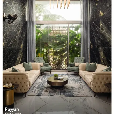 The formal living room at Rayyan, featuring tufted sofas, a dramatic marble wall, and a double-height window that looks out onto a green space.