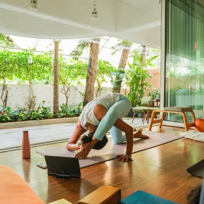 Teaching with intention, whether in person or online. Here, I'm guiding an online class while moving through a deep stretch, connected to my students through the screen.