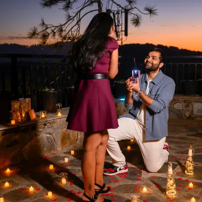 The big moment! A surprise proposal captured at dusk, with the ring box lit up and the background filled with candles and the beautiful twilight sky.