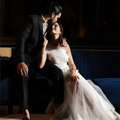 A moment of pure Hollywood glamour. The dramatic lighting, the elegant white dress against the dark suit, and the intimate pose create a cinematic and passionate portrait.
