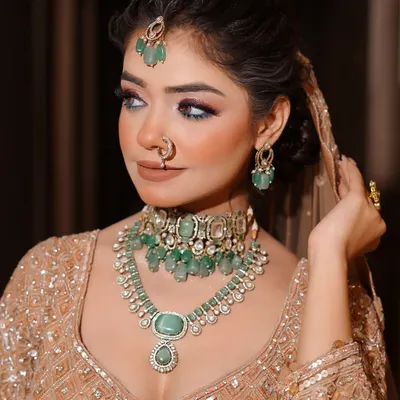 This is a perfect example of the modern bridal aesthetic I teach, featuring soft glam with emerald jewelry. The focus is on creating luminous skin and defined eyes, a look many contemporary brides request.