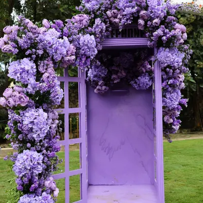 A truly unique photo booth: a vintage-style telephone booth painted purple and overflowing with matching hydrangeas.