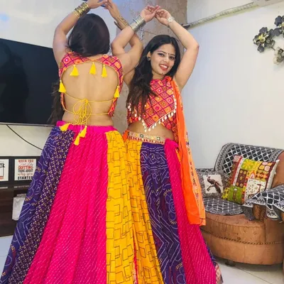 Two friends ready for Garba night in our colorful patchwork lehengas. The backless blouse design with tassels adds a playful and traditional touch.