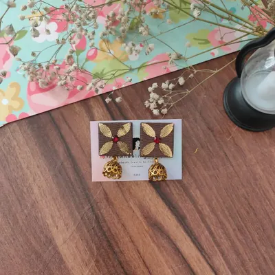 These square fabric earrings feature beautiful gotapatti work and are finished with a classic golden jhumki. This pair is in a lovely brown, perfect for pairing with earthy tones.