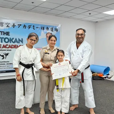 A young student proudly receives her yellow belt certificate from DCP Tanu Sharma. It is wonderful to have supportive parents and respected community members encouraging our kids.