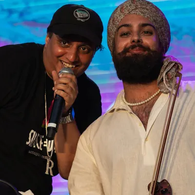 Rep the legacy. I offer official Basement Bhangra merchandise, like this classic t-shirt, so the community can carry the vibe with them everywhere. This is me with Raaginder, a brilliant violinist I've collaborated with.