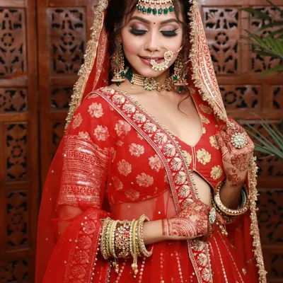 A beautiful bride in a classic red lehenga. I focused on creating a matte base with sharp contouring and defined, kohl-rimmed eyes to make her features pop under the dupatta.