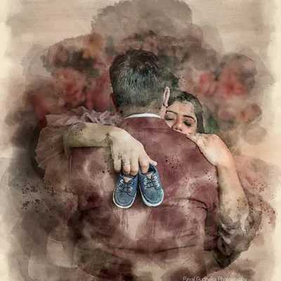 A beautiful watercolor-style edit of a maternity photo, showing a husband hugging his wife from behind as they hold tiny baby shoes. This showcases a unique, artistic way to transform a portrait into a piece of fine art.