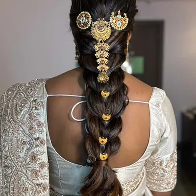 This is a classic South Indian bridal braid, also known as a 'poola jada'. I've adorned this thick, traditional choti with intricate gold temple jewelry for a truly divine look.