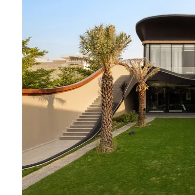 At Residence Ondra in Amritsar, movement is orchestrated for clarity and connection. A sculpted external staircase curves gracefully alongside a textured wall, leading guests directly to an upper-level party lounge while preserving the privacy of the main home.