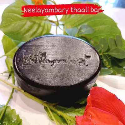 My Neelayambary Thaali Bar, resting on fresh hibiscus leaves. This solid shampoo bar is packed with herbs like hibiscus, tulsi, and brahmi to gently cleanse your hair while maintaining its natural moisture.