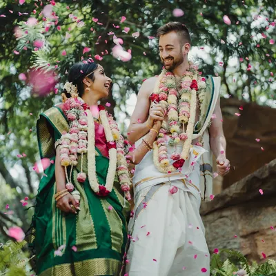 An Indian bride and her groom from New Zealand share a joyous moment, celebrating their union with a mix of South Indian and Māori traditions.