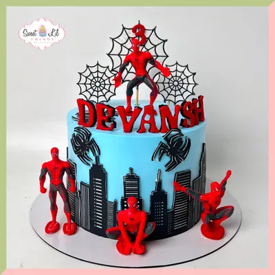 This Spider-Man cake is an action-packed scene, featuring a city skyline wrapping around the base and multiple Spidey figures in dynamic poses. The bold red and blue colors make it a visually striking centerpiece for a young superhero fan's birthday.