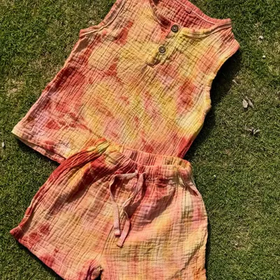 A summery organic cotton top and shorts set for kids. This outfit is hand-dyed with a blend of Indian herbs, making it gentle on the skin and beautiful to look at. Perfect for warm days and happy adventures.