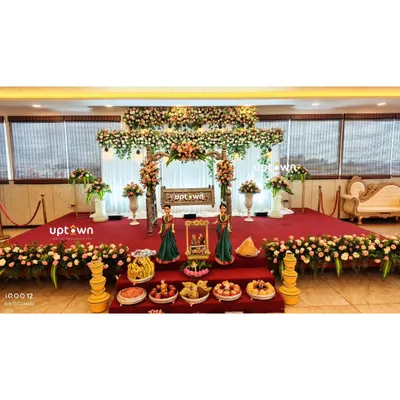 An elegant naming ceremony stage with a floral-decorated cradle and traditional offerings.