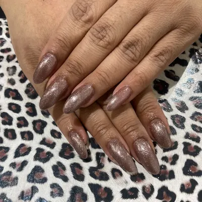 Long, almond-shaped nail extensions are perfect for creating a dramatic and elegant look. This set is finished with a sparkling bronze glitter gel polish that catches the light beautifully.