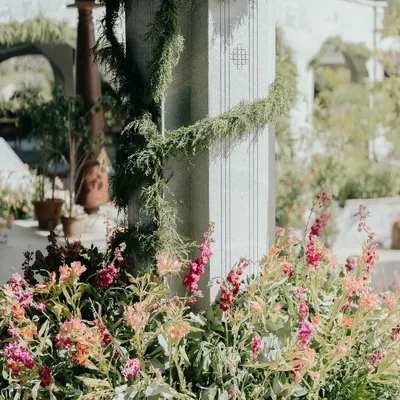 A close-up of the floral and greenery details from Nithya and Payton's wedding. We love layering different textures and colors, like these soft pink snapdragons against the cool stone pillar wrapped in delicate vines.