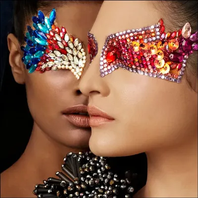 An editorial beauty shot that transforms the face into a canvas. The intricate, jewel-like masks create a stunning visual, exploring themes of identity and adornment.