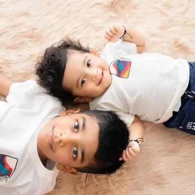 An overhead shot of two brothers lying down, sharing a moment of connection. This perspective offers a unique and intimate view of their bond.