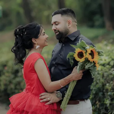 A romantic gaze shared between the couple in a serene garden setting. The sunflowers add a pop of cheerful color, symbolizing adoration and loyalty in this beautiful pre-wedding photograph.
