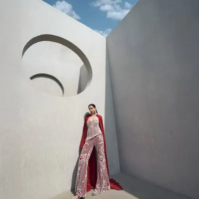 A fully pearl-embellished corset paired with tailored pants and a floor-sweeping crushed cape. This is power dressing, redefined with elegance and edge.
