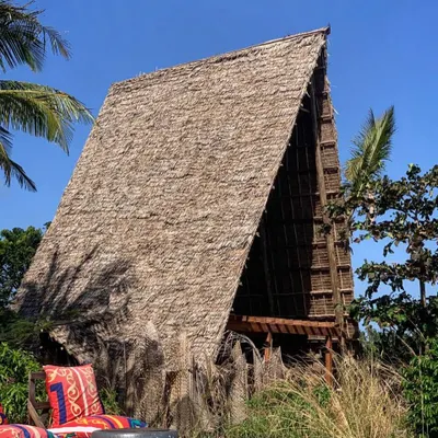 The new A-frame spa structure at Kizikula in Zanzibar, nestled in the tropical foliage. We used a traditional makuti thatch roof and an open design to create a serene space for relaxation that feels completely connected to nature.