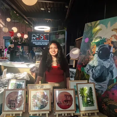 My art setup at Cafe Reset in Bangalore, featuring a variety of framed prints and a large canvas. I love creating these pop-up displays to make my art accessible in relaxed, everyday spaces.