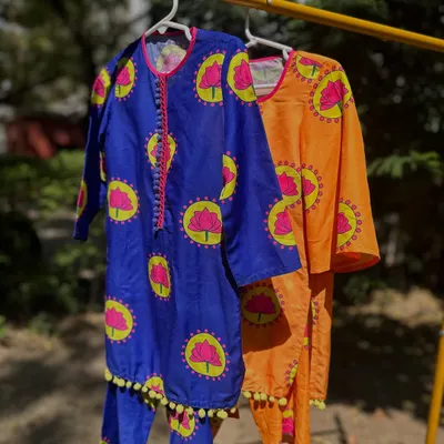 A look at my summer-ready kurta sets in royal blue and orange. The vibrant lotus print and pom-pom trim are designed to be playful and fun.
