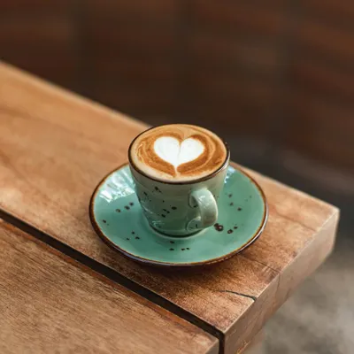 A perfectly poured cappuccino with a heart-shaped latte art, served in one of our signature ceramic cups. It's a cup of love to start your day.