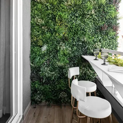 We turned this balcony into a biophilic-themed retreat with a lush vertical garden wall. The sleek white bar counter and matching stools create a perfect spot for morning coffee or evening drinks.