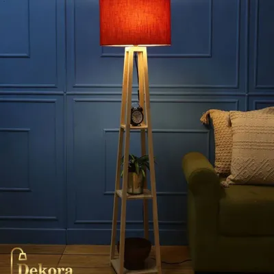 This version of our wooden shelf lamp features a bold red lampshade, adding a vibrant pop of color to the room. The functional shelves provide a perfect spot for a small clock, plant, and other decor items.