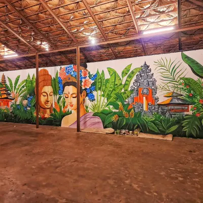 A wide view of the expansive Bali-themed mural we painted for Vanya Bangalore. The artwork wraps around the space, creating an immersive tropical escape with its depiction of Balinese temples, lush foliage, and serene figures.