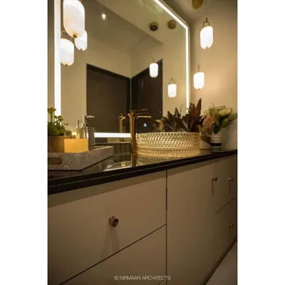 This elegant wash area in our Duplex Project features a stunning crystal-cut glass basin and gold-finished tap. The pendant lights and backlit mirror add layers of warm, ambient lighting.