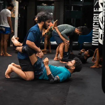 Students practice passing the guard during a Jiu-Jitsu class. This is a fundamental skill for advancing to a more dominant position.