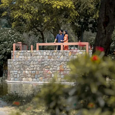 This is a classic outdoor pre-wedding portrait taken at a park in Delhi. I use natural light and scenic elements like this stone bridge to create beautiful, relaxed images for couples.