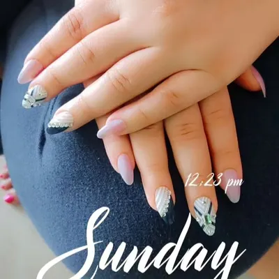 This design features a mix of textures and styles. I used a soft matte nude base with black and silver geometric patterns, plus a textured white accent nail with rhinestones for that essential bling.