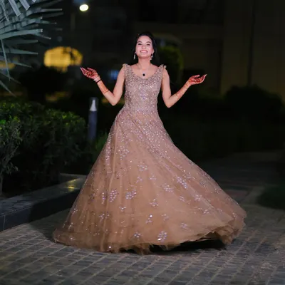 A happy and twirling engagement bride in a stunning beige gown. The makeup is kept soft and glowing to let her natural joy shine through.